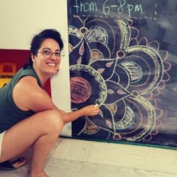 Woman drawing on a chalkboard in a hostel, creative moment in Playa del Carmen, Mexico