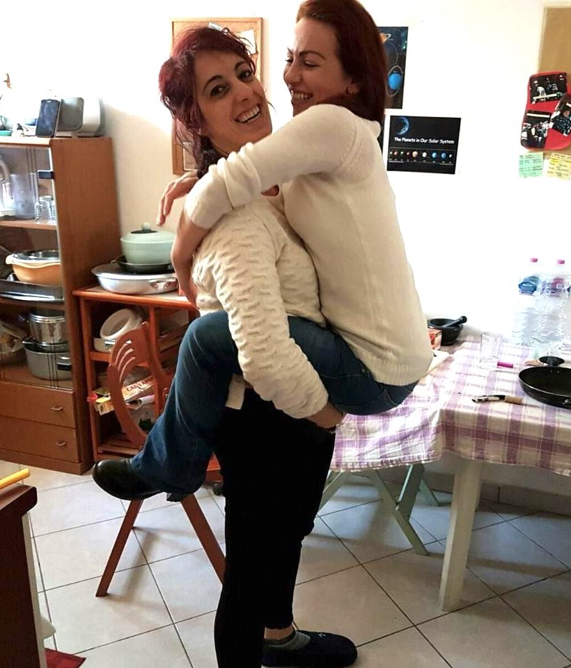 Two women hugging at home, sharing a warm and intimate friendship moment