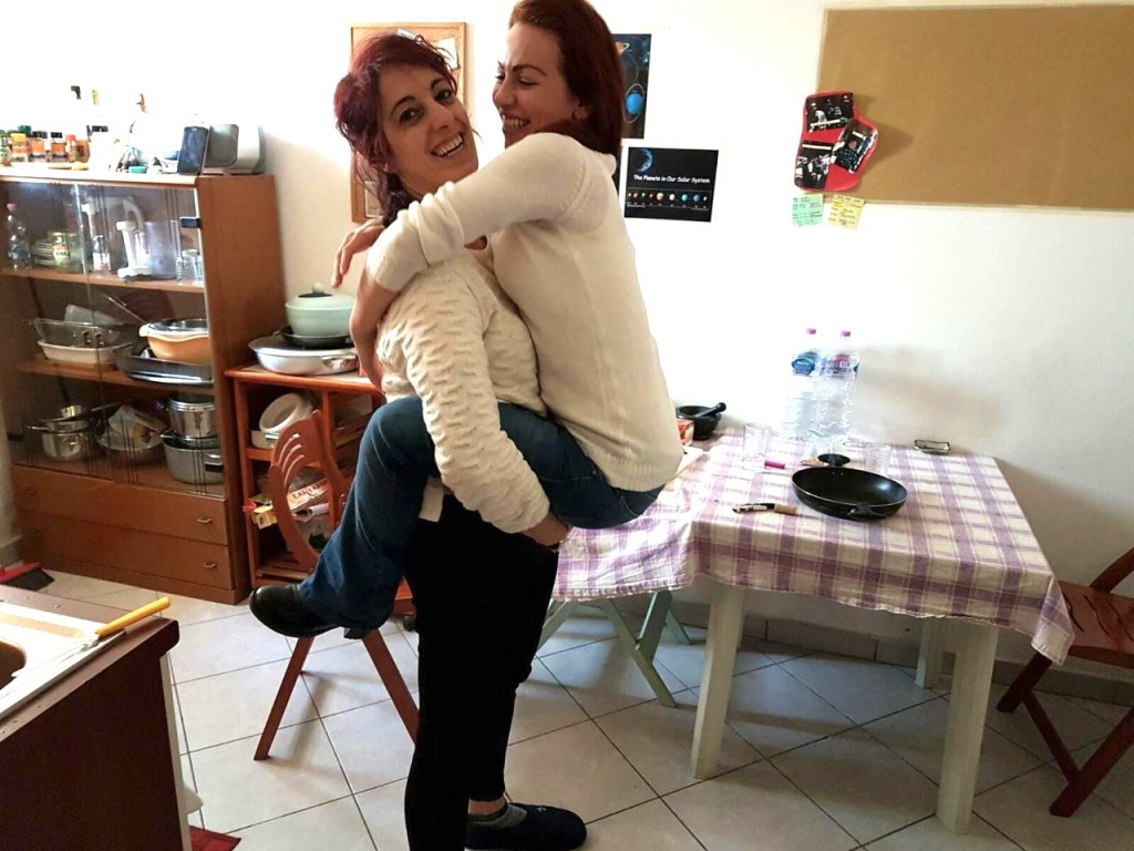 Two women hugging at home, sharing a warm and intimate friendship moment