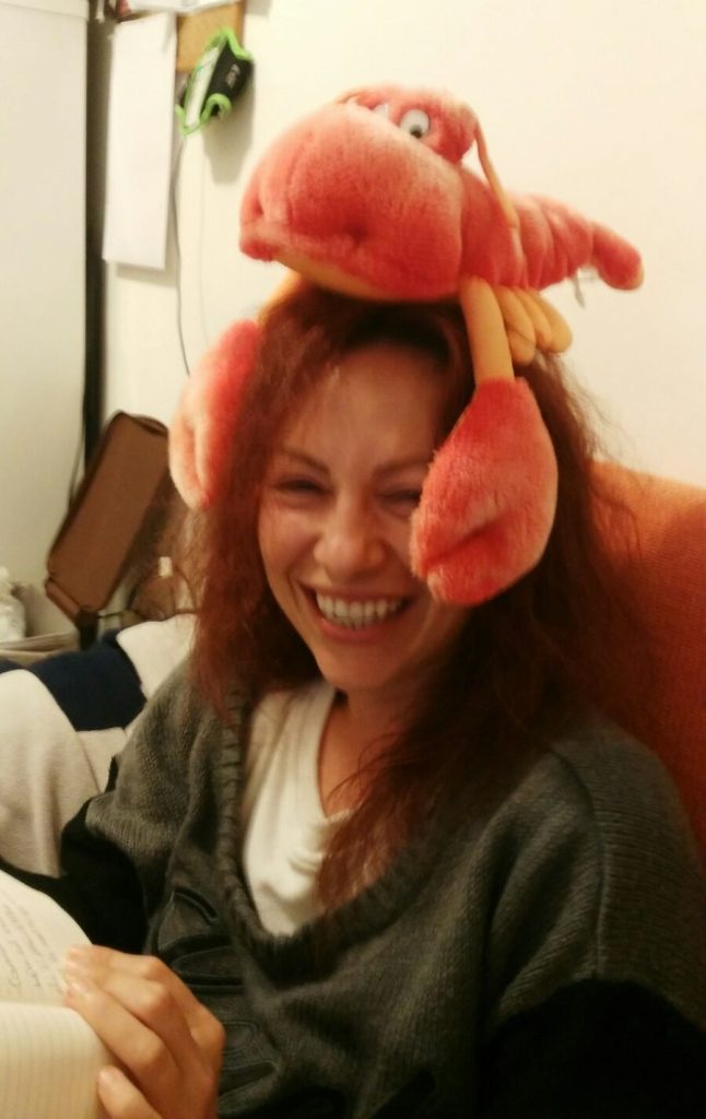 Woman laughing with a playful toy on her head, capturing a spontaneous funny moment